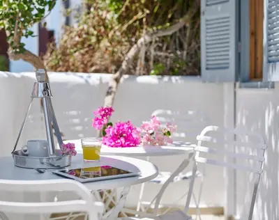 a white table and chairs with a drink on it at Kalithea Hills Appartment 1 in Koskinou