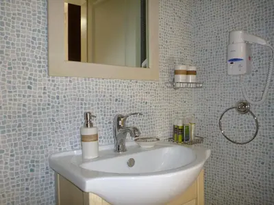 a bathroom with a white sink and a mirror at Bright Sun Villas in Halki