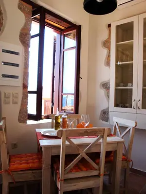 a kitchen with a table and chairs and a window at Bright Sun Villas in Halki