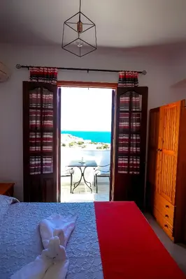 a bedroom with a bed and a view of the ocean at Domna Studios in Líndos