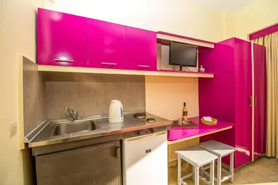 a kitchen with purple cabinets and a sink at Takis Hotel Apartments in Ialyssos