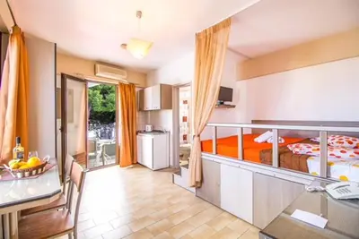 a large room with a bed and a kitchen at Takis Hotel Apartments in Ialyssos