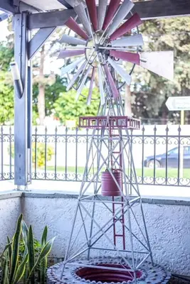 a metal windmill sitting on a porch next to a fence at Takis Hotel Apartments in Ialyssos