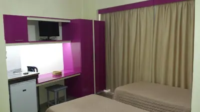 a hotel room with purple walls and a desk with a mirror at Takis Hotel Apartments in Ialyssos