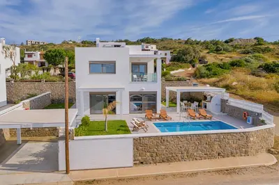 a large white house with a swimming pool at Villa Sea La Vie in Kiotari
