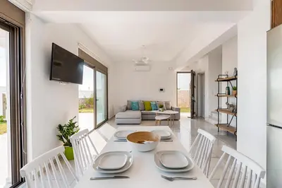 a white dining room with a table and chairs at Villa Sea La Vie in Kiotari