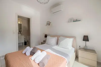 a white bedroom with a bed with towels on it at Villa Sea La Vie in Kiotari