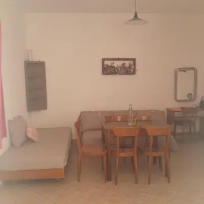 a living room with a table and chairs and a couch at Apostolis studios Pefki Lindos Rhodes in Pefki Rhodes