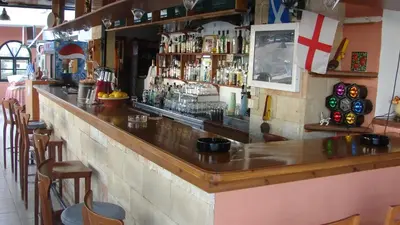 a bar in a restaurant with a wooden counter top at Apostolis studios Pefki Lindos Rhodes in Pefki Rhodes