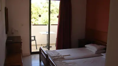 a bedroom with a bed and a window with a table at Apostolis studios Pefki Lindos Rhodes in Pefki Rhodes