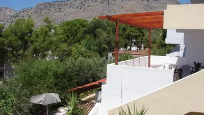 a view from the balcony of a house with an umbrella at Apostolis studios Pefki Lindos Rhodes in Pefki Rhodes