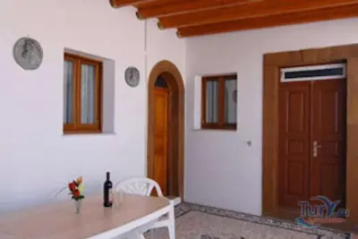a room with a table and a wooden door at Villa Koki Studios in Líndos