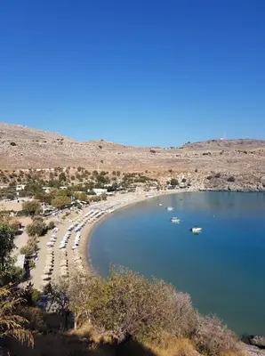 a beach with boats in a body of water at Villa Koki Studios in Líndos