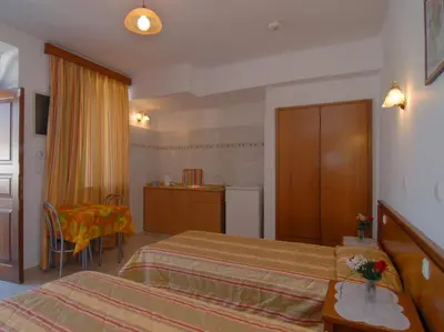 a hotel room with two beds and a table at Villa Koki Studios in Líndos