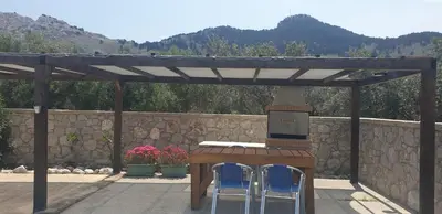 a patio with a table and two chairs under a pergola at Stergios villa in Kolimbia