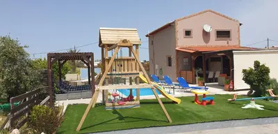 a playground with a slide and a swing set at Stergios villa in Kolimbia