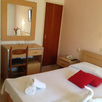a bedroom with a bed and a desk and a mirror at Zefyros Hotel in Rhodes Town