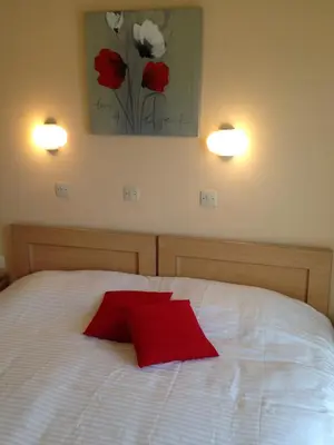 a bedroom with a bed with a red pillow on it at Zefyros Hotel in Rhodes Town