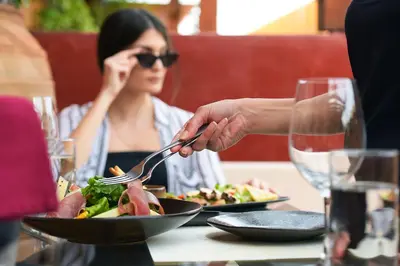 a woman sitting at a table with a plate of food at 10GR Boutique Hotel & Wine Bar in Rhodes Town