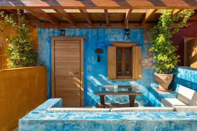 a blue house with a wooden door and a table at 10GR Boutique Hotel & Wine Bar in Rhodes Town