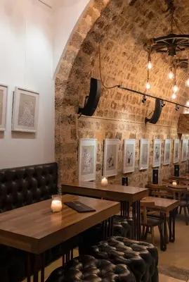 a restaurant with tables and chairs and a brick wall at 10GR Boutique Hotel & Wine Bar in Rhodes Town