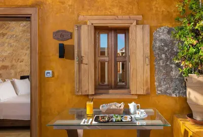 a table with a plate of food next to a window at 10GR Boutique Hotel & Wine Bar in Rhodes Town