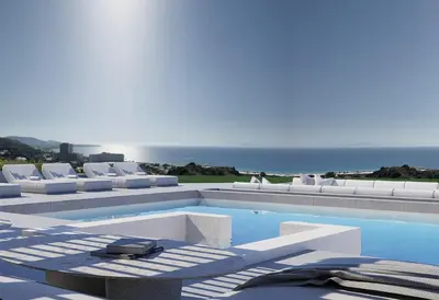 a swimming pool with white lounge chairs and the ocean at Monte Smith Luxury Villas in Rhodes Town