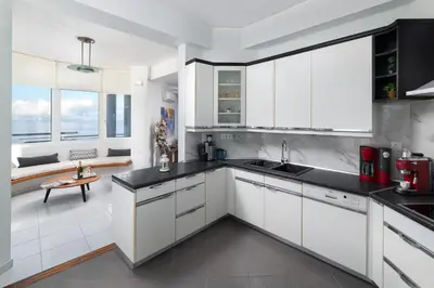a kitchen with white cabinets and black counter tops at Monte Smith Luxury Villas in Rhodes Town
