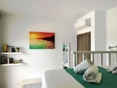 a white bedroom with a bed and a painting on the wall at Gennadi Villa Mary in Gennadi