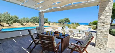 a patio with a table and chairs and a pool at Gennadi Villa Mary in Gennadi