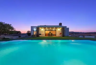 a large swimming pool in front of a villa at CRISTELIA SEAFRONT & POOL VILLA in Lachania