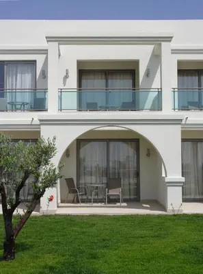 a large white house with a table and chairs at Apollo Blue in Faliraki
