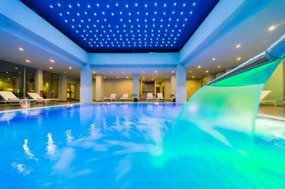 a swimming pool in a hotel with a blue ceiling at Apollo Blue in Faliraki