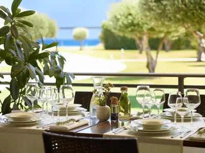 a table with wine glasses and plates on it at Apollo Blue in Faliraki
