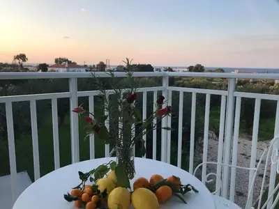 a vase of fruit on a table on a balcony at Filoxenia Apartments & Studios in Theologos
