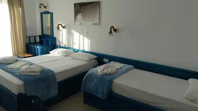 two beds in a room with blue and white at Filoxenia Apartments & Studios in Theologos