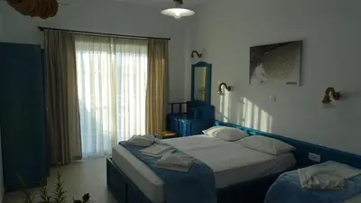 a bedroom with two beds and a window at Filoxenia Apartments & Studios in Theologos