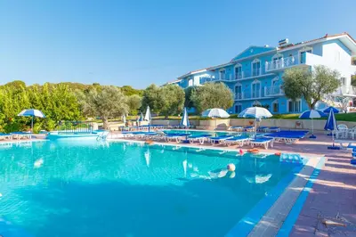 a swimming pool in a hotel with a person in the water at Filoxenia Apartments & Studios in Theologos