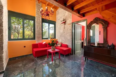 a living room with red furniture and a mirror at Eleftherias Garden House in Afantou