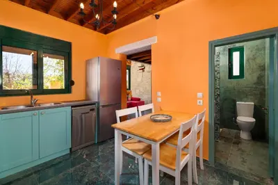 a kitchen with a wooden table and a refrigerator at Eleftherias Garden House in Afantou