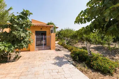 a house with a gate in front of a driveway at Eleftherias Garden House in Afantou