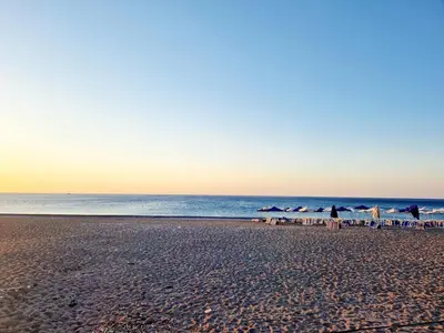 a beach with umbrellas and chairs and the ocean at Eleftherias Garden House in Afantou