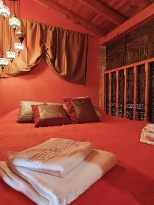 a red bedroom with a bed with a blanket on it at Eleftherias Garden House in Afantou