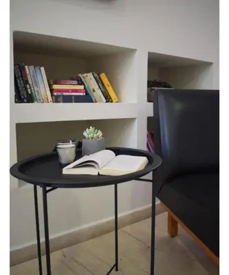 a round black table with a book and a chair at Majestic Hotel - Adults Only in Rhodes Town
