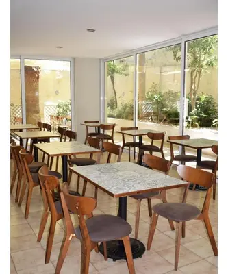 a row of tables and chairs in a room with windows at Majestic Hotel - Adults Only in Rhodes Town