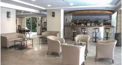 a bar with white chairs and a counter at Majestic Hotel - Adults Only in Rhodes Town