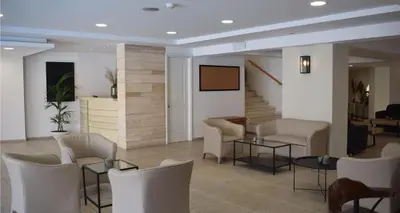 a waiting room with chairs and tables and a screen at Majestic Hotel - Adults Only in Rhodes Town