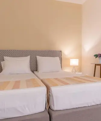 two beds sitting next to each other in a bedroom at Majestic Hotel - Adults Only in Rhodes Town