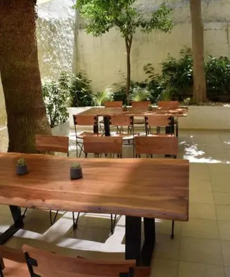 a group of wooden tables and chairs in a building at Majestic Hotel - Adults Only in Rhodes Town