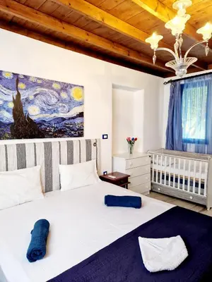a bedroom with a large bed with a painting on the wall at Lianas Garden House in Rhodes Town